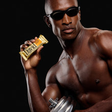 Muscular man holding a David protein bar and dumbbell against a black background
