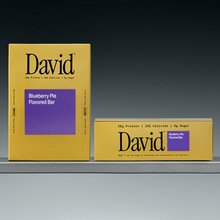 Two David Blueberry Pie Flavored Bar boxes on a gray surface with a black background