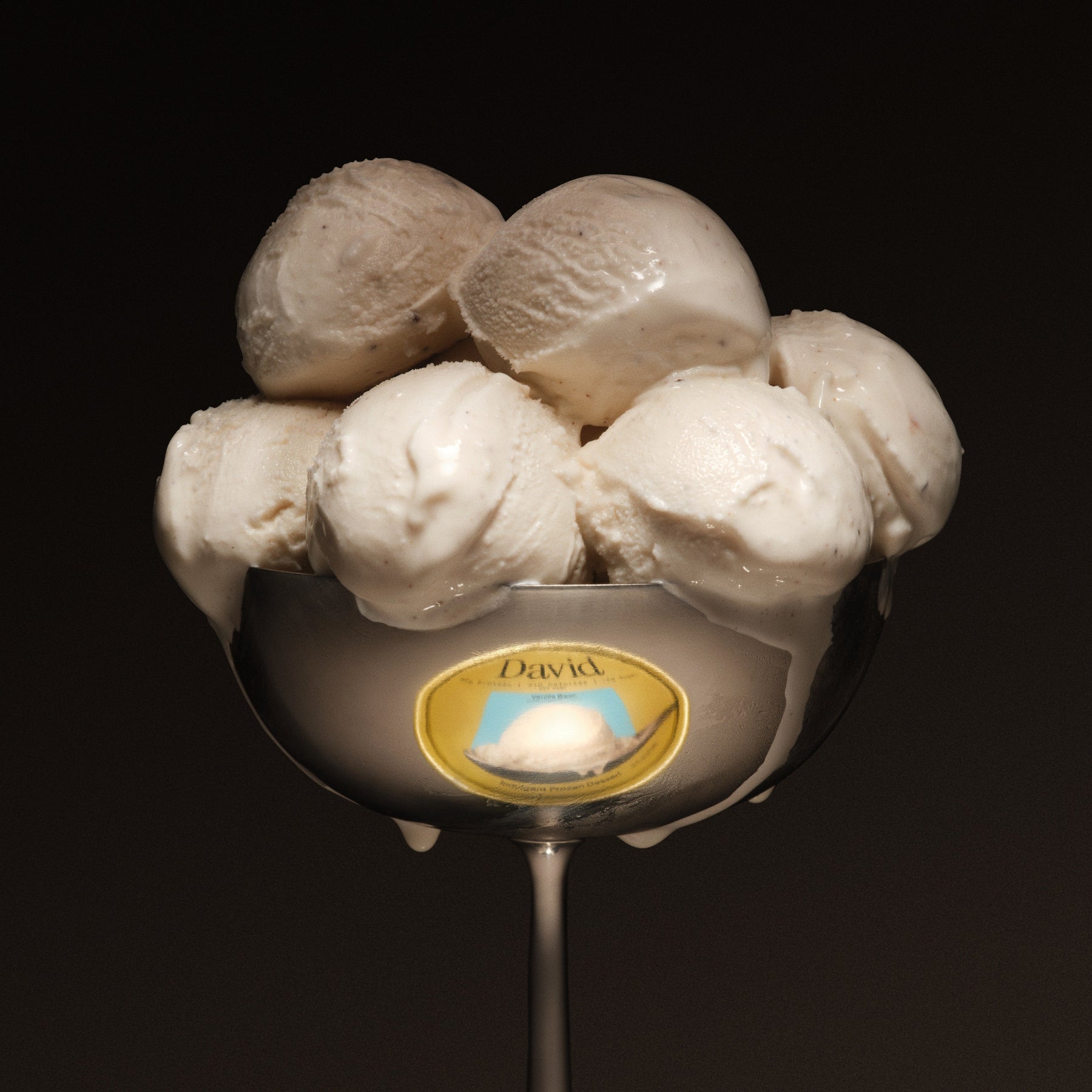Spoon with six scoops of frozen dessert on a black background