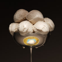 Spoon with six scoops of frozen dessert on a black background
