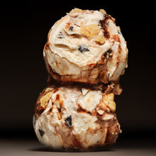 Two scoops of ice cream stacked on a dark background